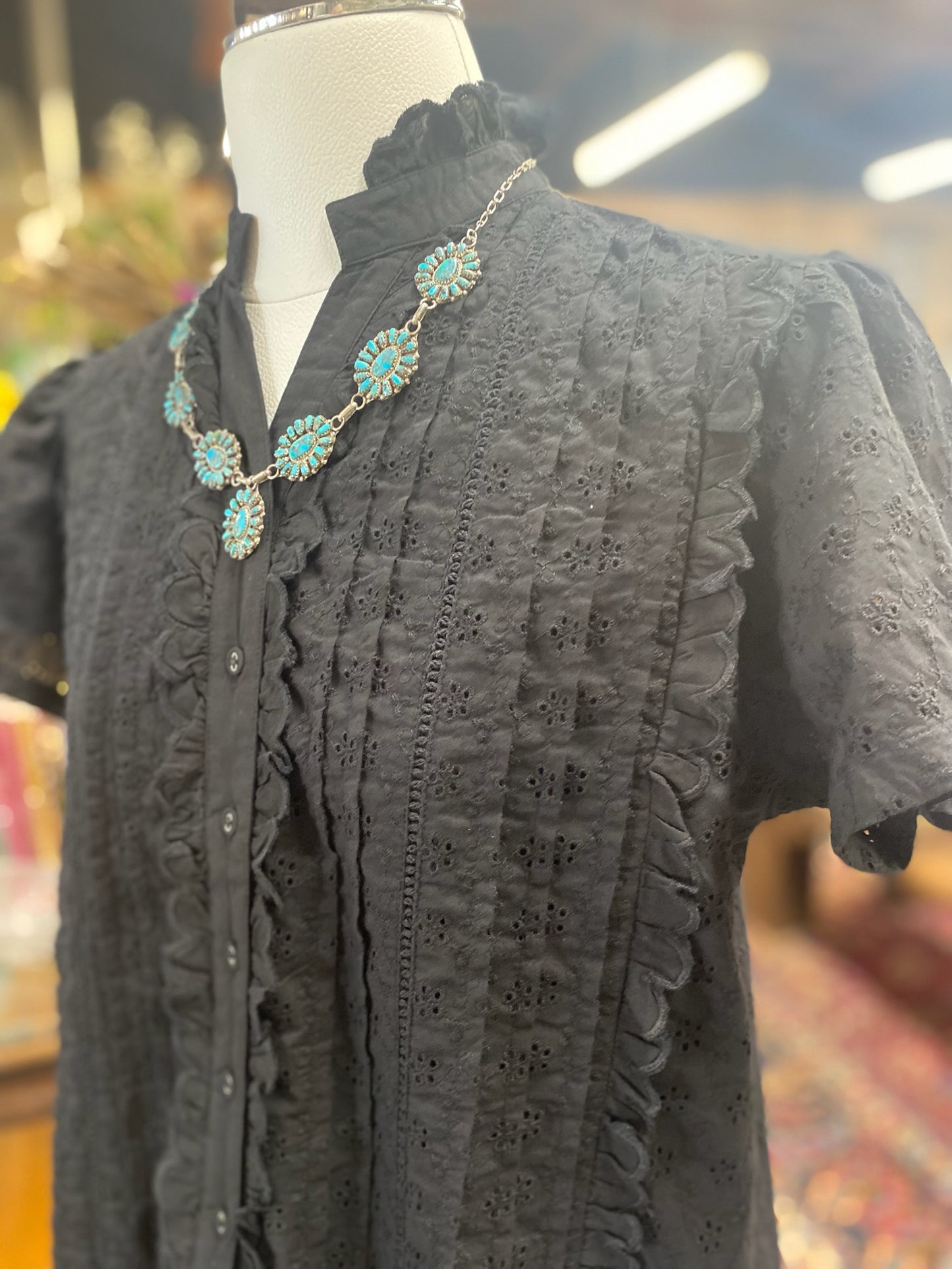 close-up of black eyelet cotton top with ruffled trim and buttons