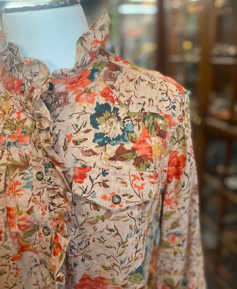Close up of floral pattern and snap closure detail on cotton eyelet shirt.
