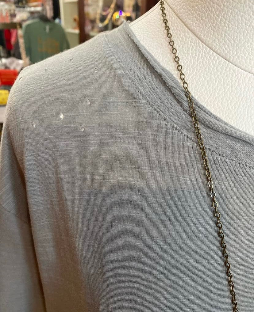 close up showing distressed detailing on shoulder of slate cotton basic tee