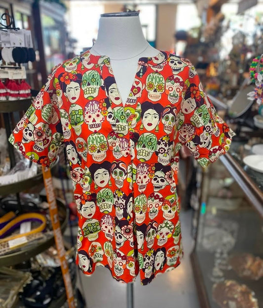 red top with colorful skulls and faces in a fiesta themed print