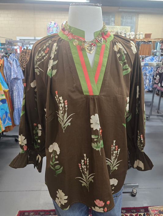 brown floral top with green and pink neckline trim on mannequin
