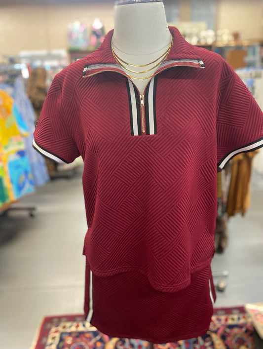 maroon zip-up polo top and skort set with short sleeves and black white trim